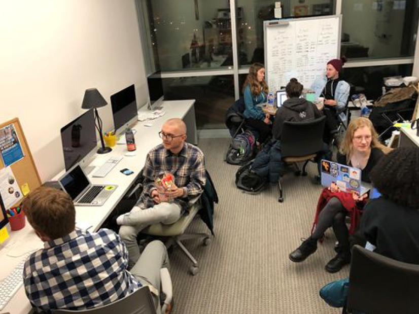 Seven workers chatting and working in the lab.