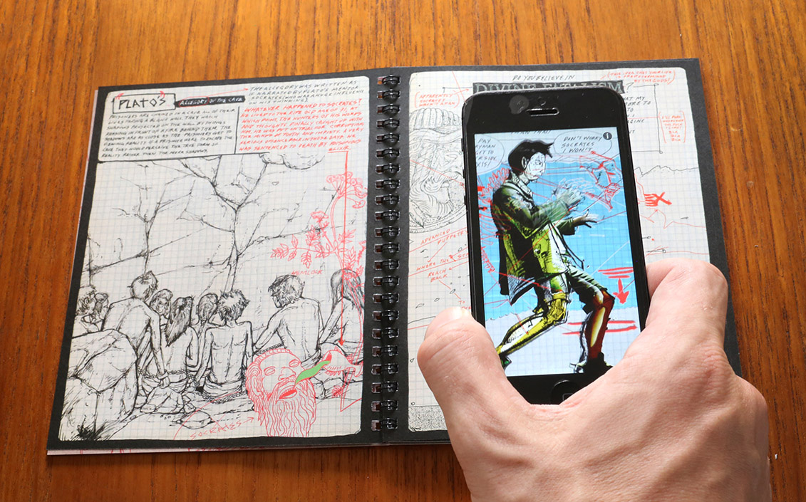 a photo depicting the reading experience of Modern Polaxis. The comic is laid open on a table, and the reader's hand is visible holding a phone above one of the pages. On the phone screen, we see an altered version of the comic page, featuring more color.