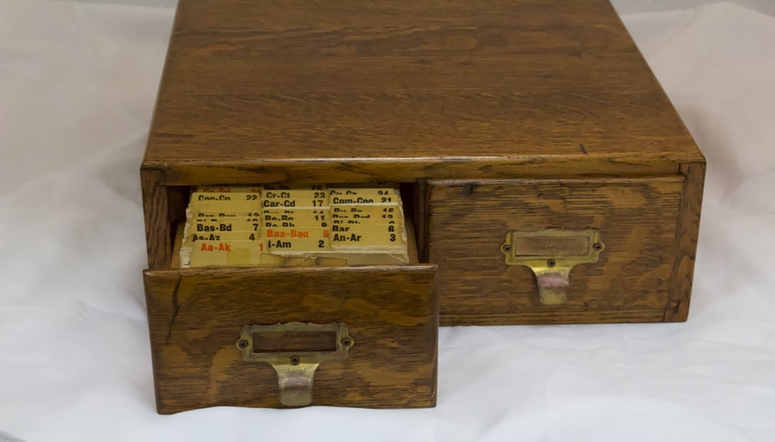 Wooden file box with one draw open to show files.