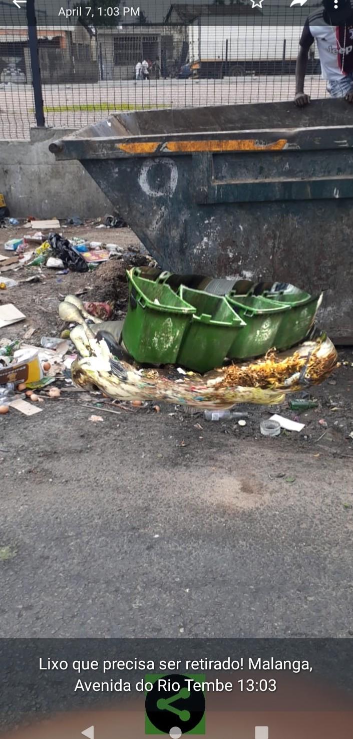 Image of an empty waste container surrounded by garbage. The trash snail AR image floats on the ground in front of the container.