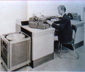 A man sits at an old computer